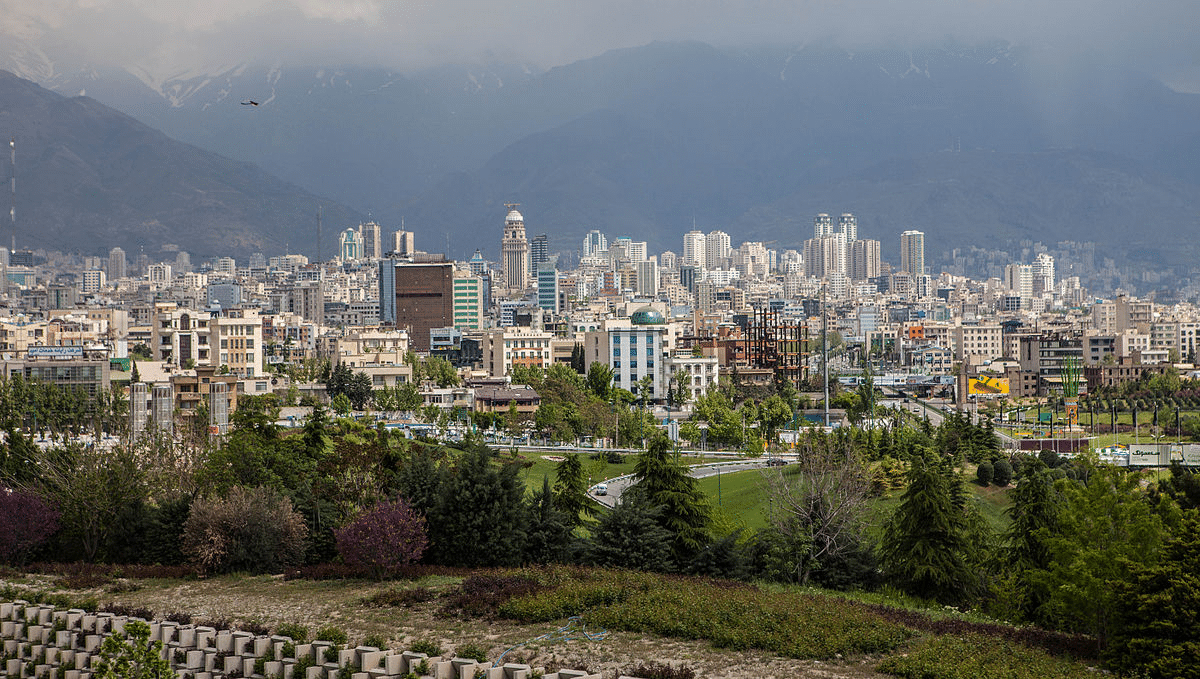 Iran is bracing itself for U.S. sanctions and inflation. This images shows the city of Tehran, the capital of Iran, with mountains and fog in the background.