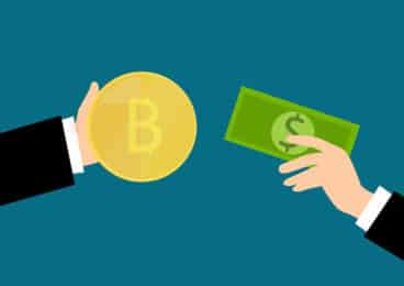 How to buy bitcoin with cash: a cartoon image of two hands, one holding a bitcoin, the other a dollar bill.